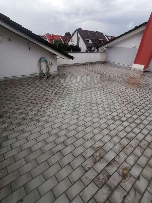 Neu belegte Dachterrasse mit Pflasterbelag und Anschluss an die Attika