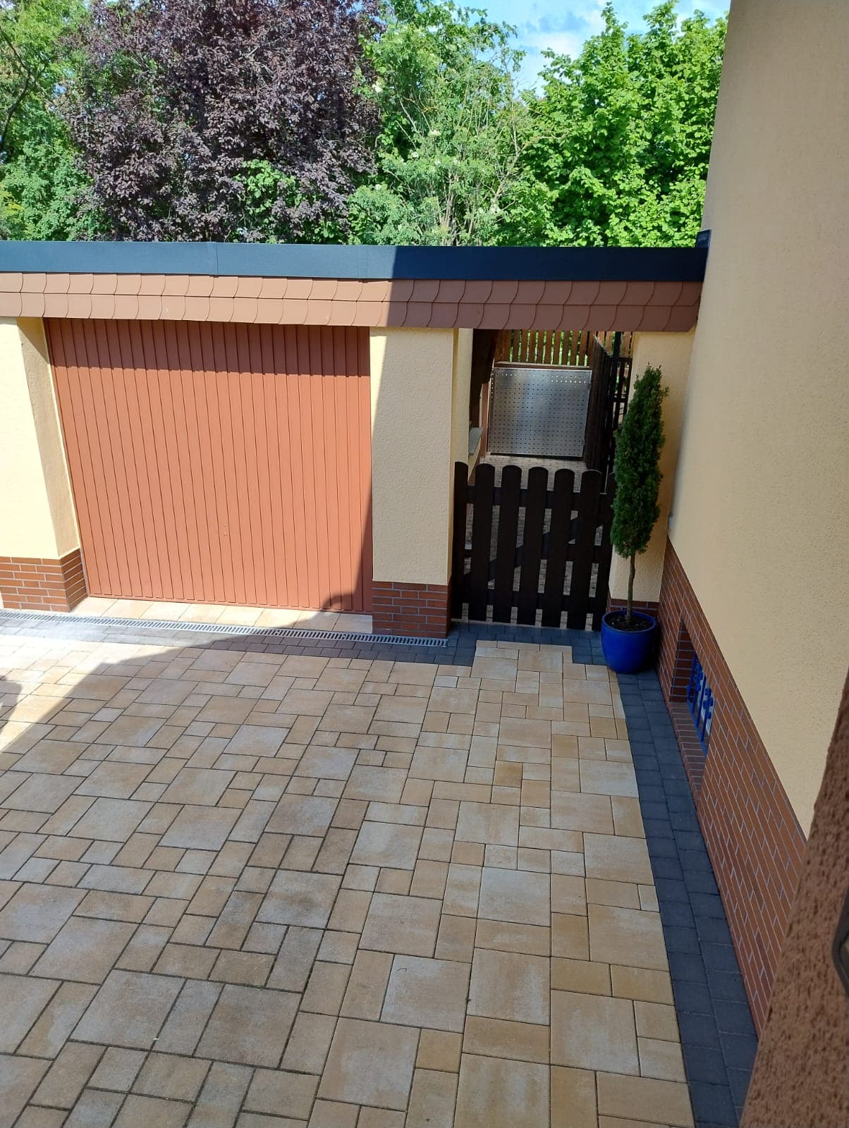 Sanierte Garage mit Carport, sauber eingefasster Dachrand und gepflastertem Hof