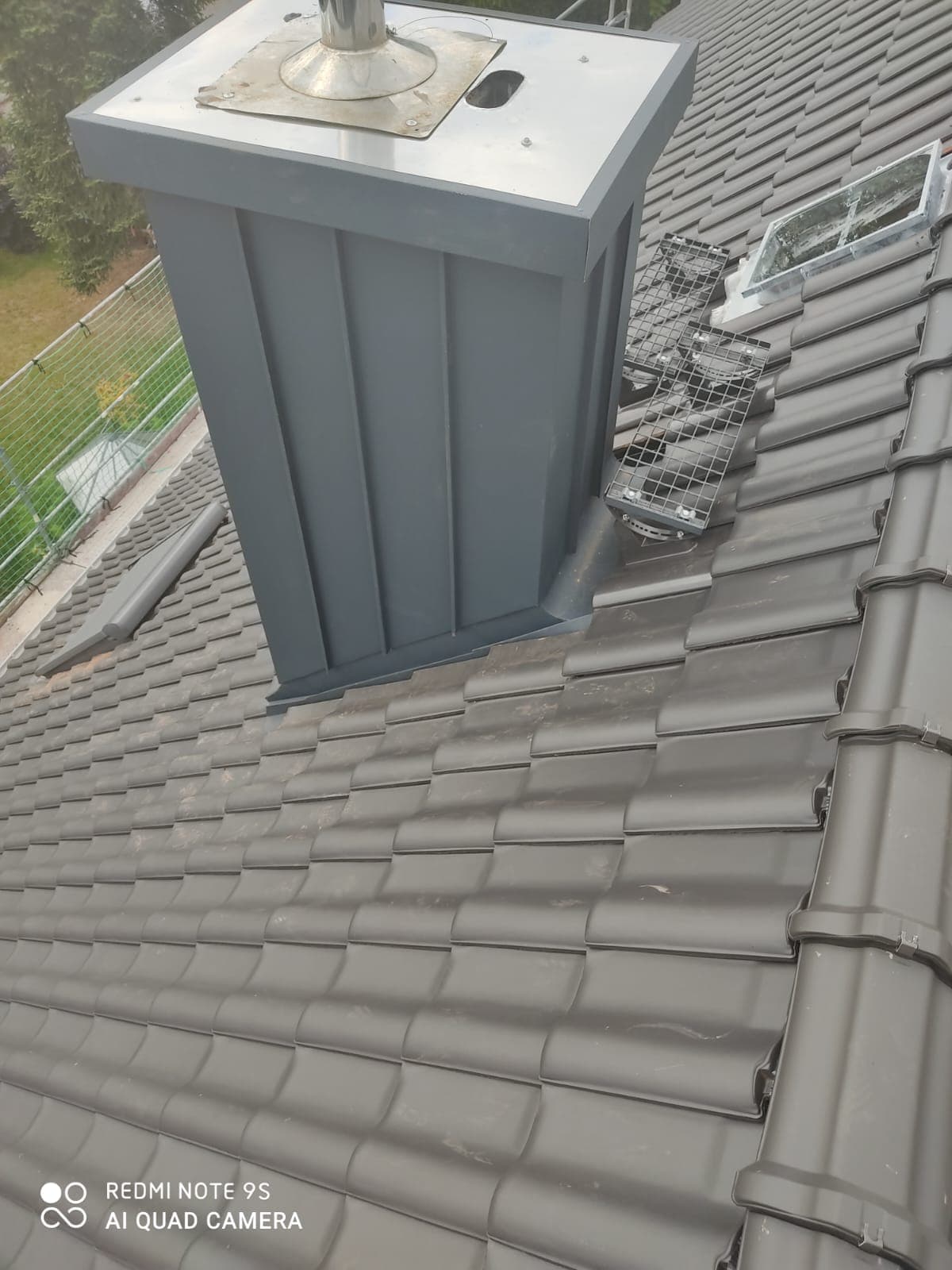 Anthrazitfarben verkleideter Kamin mit neuer Verblechung auf einem Ziegeldach